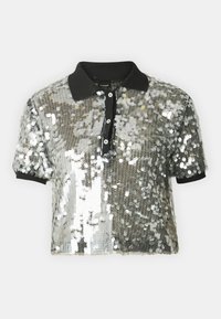 Polo a maniche corte tagliato con paillettes argento, colletto nero e pattina con bottoni. Superficie testurizzata con effetto lucido.