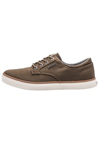 Brown canvas sneaker with white rubber sole, leather accents, four eyelets, and "JOOP!" logo on the side. Smooth texture and low-top design.