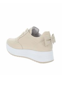 Beżowe sneakersy z teksturowaną cholewką, gładkim wykończeniem i białą platformą. Posiadają mały detal w postaci kokardki z tyłu.