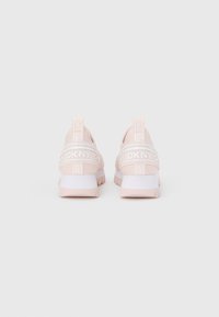 Chaussures de sport rose clair avec une tige en mesh, arborant une bande blanche avec le logo DKNY et une semelle blanche unie avec une adhérence texturée.