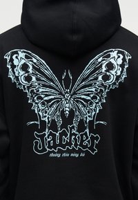 Črni pulover s kapuco z veliko podrobno modro metuljevo grafiko in stiliziranim napisom "Jacker" ter manjšimi kitajskimi znaki spodaj na zadnji strani.