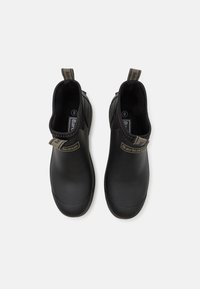 Bocanci de gleznă din cauciuc negru, cu un design elegant, dotati cu panouri elastice laterale, mânere de tragere și branding subtil pe curele.