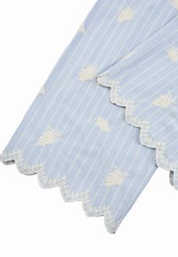 Tissu bleu clair à rayures blanches verticales, avec des grappes de raisins florales blanches brodées et des bords en dentelle florale festonnée.