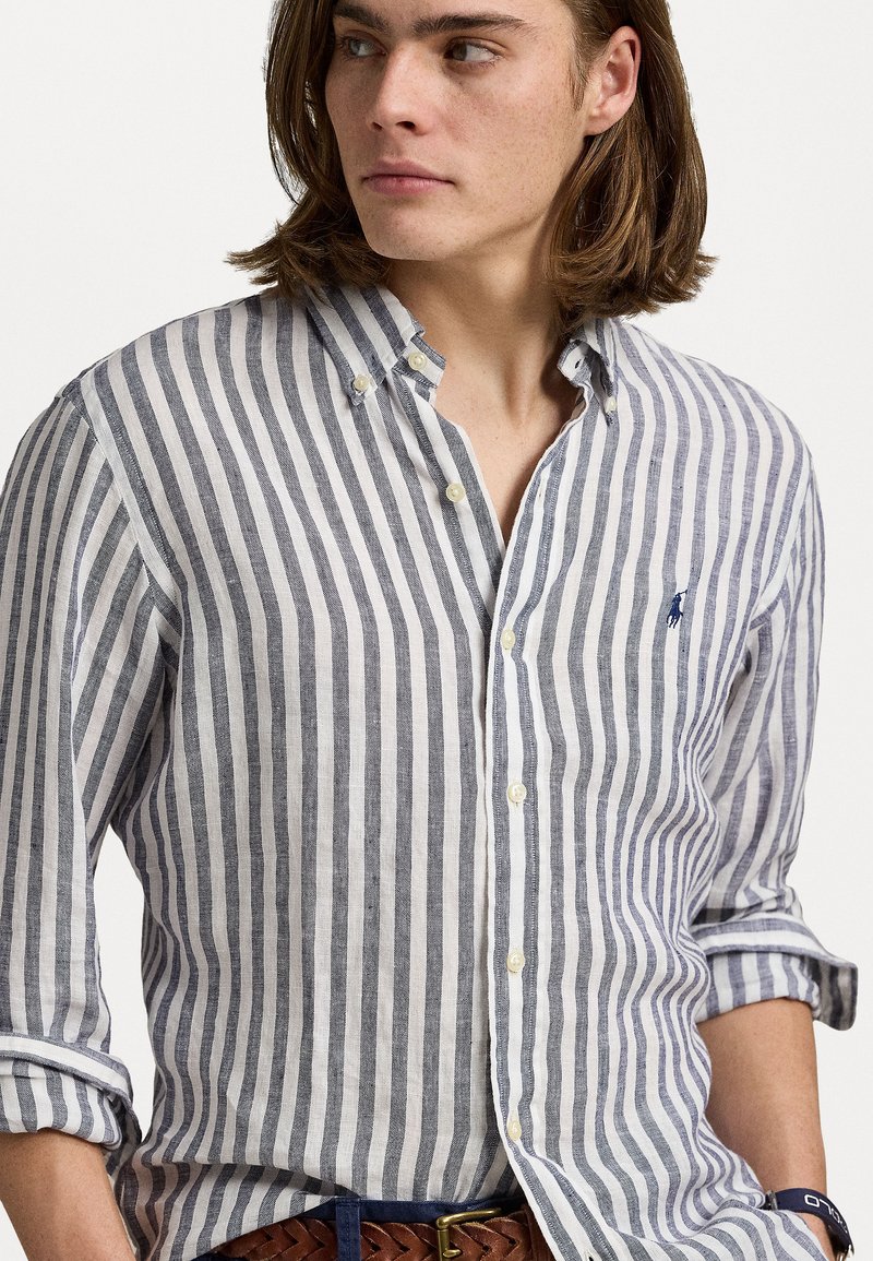 Lichte gestreepte shirt in blauw en wit, met een button-down kraag, lange mouwen en een klein logo op de borst. Textuurstof.