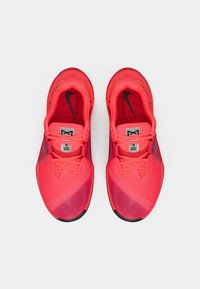 Λαμπερά ροζ αθλητικά παπούτσια με υφή στην επάνω πλευρά, μαύρες λεπτομέρειες και ένα ξεχωριστό μοτίβο. Διαθέτουν κλείσιμο με κορδόνια και αφρώδεις σόλες.