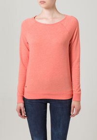 Korálová mikina s kulatým výstřihem a dlouhými raglánovými rukávy, žebrované manžety a lem. Vyrobena z měkké, strukturované tkaniny. Malý detail s logem dole.