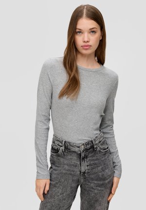 Lichtgrijs langetermijnshirt in een getailleerd ontwerp, gecombineerd met zwart-denim jeans met hoge taille die een lichte vervaging en steekzakken hebben.