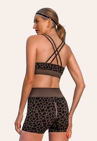 Bruin luipaardprint sportbeha en short set met kruislingse banden en een hoge tailleband, gemaakt van een zachte, rekbare stof.
