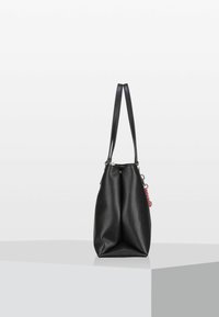 Sac fourre-tout en cuir noir avec une surface texturée, doté de deux longues poignées et d'un petit pendentif rose attaché. Fermeture éclair sur le dessus.