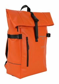 Mochila impermeable naranja con un diseño de parte superior enrollable, que presenta correas y herrajes negros, un bolsillo frontal con cremallera y un logotipo en gris.