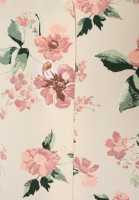 Ύφασμα κρεμ με ροζ και καφέ floral σχέδιο, πράσινα φύλλα και λευκά κουμπιά τοποθετημένα κάθετα στο κέντρο.