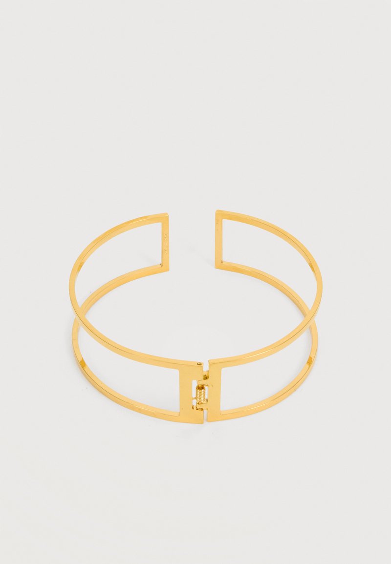 Ελαφρύ βραχιόλι ανοιχτού τύπου σε χρυσό τόνο με ορθογώνιο ελατήριο κούμπωμα, απεικονισμένο σε απλό λευκό φόντο.