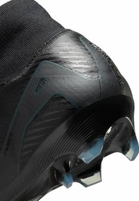 Schwarzer synthetischer Fußballschuh mit einer strukturierten Oberfläche, einem gestrickten Knöchelbund, winkelförmigen Designelementen und transparenten Stollen.