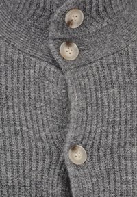Szary dziergany kardigan z prążkowanym wzorem, trzema dużymi kremowymi guzikami i wysokim dekoltem. Miękka i ciepła tkanina.