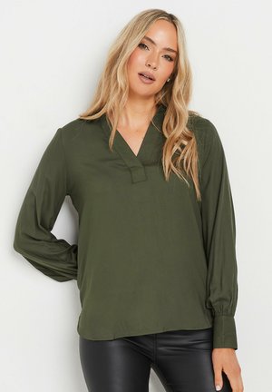 Blusa verde oliva a maniche lunghe con scollatura a V e polsini arricciati, caratterizzata da una texture liscia e una vestibilità rilassata. Orlo dritto.
