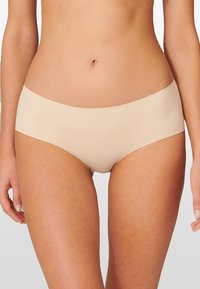 Beige naadloze hipster onderbroek met een zachte, elastische textuur en een medium hoge taille. Heeft geen zichtbare naden of hardware accenten.