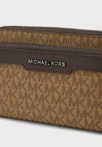 Καφέ πορτοφόλι με μονογράμμα υπογραφή, με υφή, που διαθέτει σκουρόχρωμο καφέ δερμάτινο στοιχείο και ασημί λογότυπο "Michael Kors".