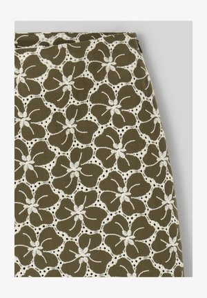 Tissu vert olive avec un motif répétitif de grands motifs floraux brodés blancs, comprenant cinq pétales chacun.