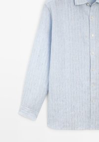Lichtblauw langemouwenshirt met fijne verticale witte en donkere strepen, knoopsluiting aan de voorkant en enkel-knoop manchetten.