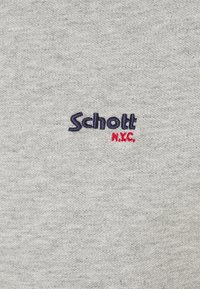 Szary bawełniany materiał z teksturą; z haftowanym napisem "Schott" w niebieskim i "N.Y.C." w czerwonym. Prosty design bez dodatkowych wzorów czy akcentów.