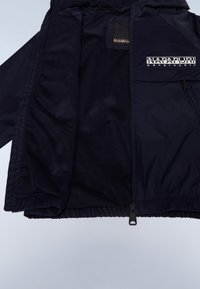 Granatowa kurtka wiatrówka z siateczkową podszewką, elastycznymi mankietami i ściągaczem u dołu, z naszywką z logo na przedniej kieszeni.