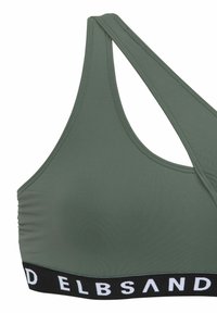 Sportiva verde oliva con fascia nera a coste che presenta testo bianco, spalline regolabili, tessuto liscio e dettagli arricciati sui lati.