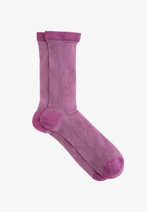 Violetas zeķes, kas izgatavotas no mīksta auduma ar gludu apdari un ribām ap manžetēm. Tām ir pastiprinātas pirkstu un papēžu zonas, lai nodrošinātu izturību.