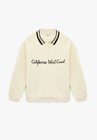 Kremowa koszulka polo z długim rękawem, z czarnymi podwójnymi paskami na kołnierzyku oraz napisem "California West Coast" na przodzie w czarnym kolorze.