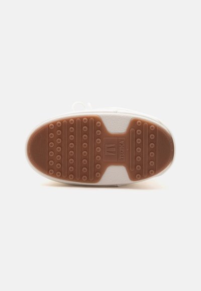 Semelle de chaussure avec semelle en caoutchouc marron présentant des grips circulaires en relief et des bandes, une semelle intermédiaire blanche, et une indication de la taille visible au centre.
