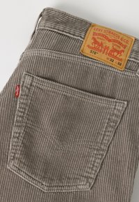Γκρι παντελόνι Levi's από κορντόνι με πίσω τσέπη και καφέ δερμάτινη ετικέτα με μέγεθος W32 L32 στη μέση.
