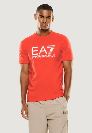 T-shirt rossa in cotone con scollo tondo e maniche corte, con logo bianco "EA7 Emporio Armani" stampato sul davanti.