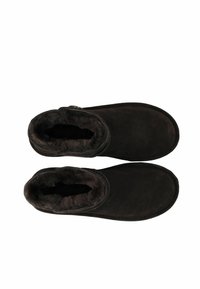 Braune Wildleder-Stiefeletten mit Kunstfellfutter, runder Zehenform und seitlichem Knopfakzent. Glatte Textur und weiche Verarbeitung überall.