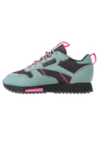 Tenisky s horní částí z mátově zeleného semiše, černou síťovinou, růžovými akcenty a gumovou podrážkou s texturovaným vzorem.