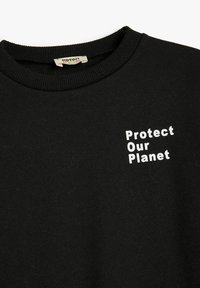 Zwarte sweatshirt van katoen met een geribde kraag. Voorzien van witte tekst "Protect Our Planet" in twee regels op de voorkant.