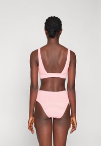 Črtast bikini komplet z teksturirano površino; zgornji del ima široke naramnice in nizek hrbet, spodnji del pa je s visokim pasom in zmerno prekritostjo.