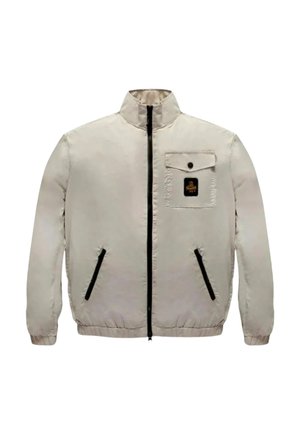 Giacca beige chiaro con cerniera frontale, collo alto, due tasche laterali con cerniere nere e una tasca sul petto con bottone, decorata con un piccolo logo nero e oro.