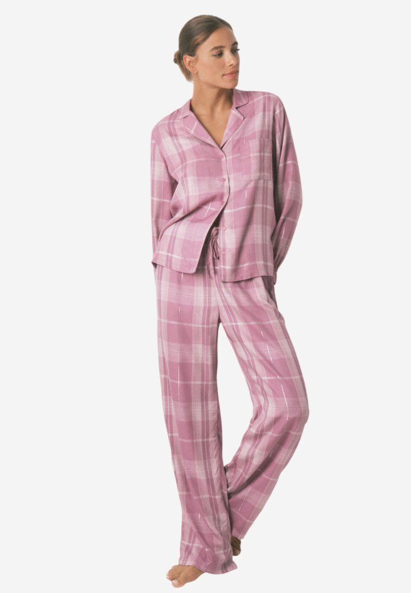 Lyserød ternet pyjamassæt lavet af blødt stof. Overdelen har krave og knapper; bukserne har en elastisk talje og løs pasform.