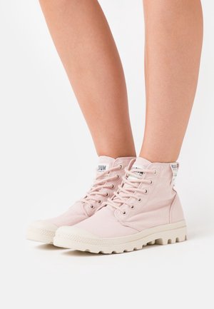Roze hoge sneakers met een bovenwerk van canvas, rubberen neuskap en een gestructureerde zool. Beschikt over metalen veterogen en merkopdruk op de tong en hiel.