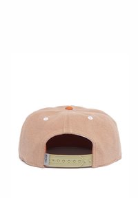 Beige Snapback-Cap mit flachem Schirm, weißen Belüftungsösen und einem orangenen Knopf oben. Verfügt über einen verstellbaren beigen Riemen auf der Rückseite.