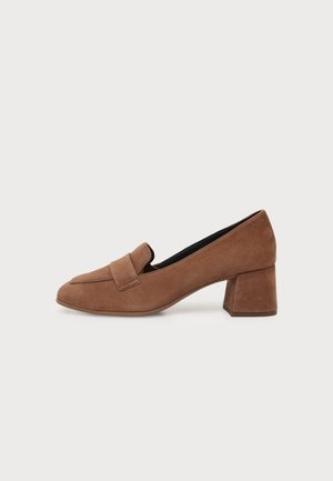 Mocasín de ante marrón con tacón bajo cuadrado y punta redondeada, mostrado de lado sobre un fondo blanco liso.
