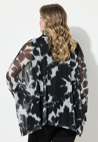 Kimono trasparente nero e grigio con motivo astratto, maniche ampie e design fluido, caratterizzato da una texture sottile e tessuto leggero.