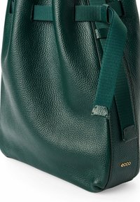 Borsa a tracolla in pelle verde con finitura texturizzata, dotata di due manici in tessuto e un accento in oro con logo sul lato. Design minimalista.