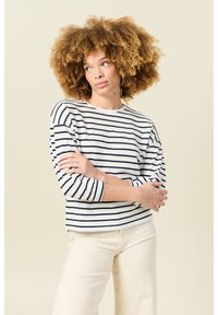 Langärmliges gestreiftes Oberteil in Creme und Marineblau, mit Rundhalsausschnitt und lockerer Passform, aus weichem Baumwollstoff mit leichter Textur.