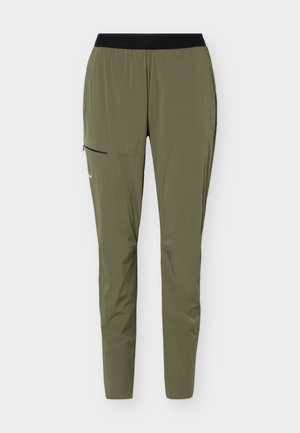 Olivengrønne tilspissede treningsbukser med svart elastisk midjebånd og en glidelåslomme på øvre venstre lår.