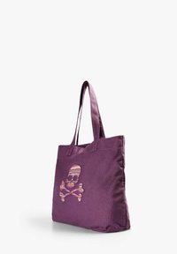 Bolso de lona púrpura con un diseño bordado de calavera y tibias cruzadas, adornado con acentos coloridos y estampados. Dos asas resistentes.