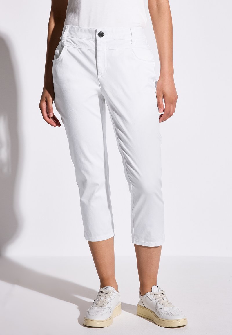 Witte cropped broek gemaakt van lichtgewicht stof, met zijzakken, een knoopsluiting aan de voorkant en een relaxte pasvorm. Gekocht met beige sneakers.