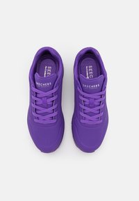 Purple athletic shoes with a smooth synthetic upper, padded collar, perforated toe box, and flat laces. Logo on tongue. Textured insole.