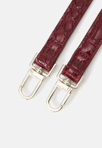 Burgundy lackläderrem med krokodilstruktur, med guldfärgad metallhårdvara och clips för fäste.