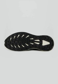 Suola di scarpa sportiva nera con gomma testurizzata per una migliore aderenza, con un battistrada a motivo e dettagli bianchi. Forma curva per migliorare le prestazioni.