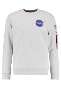 Sudadera gris con el logotipo de la NASA impreso en azul y rojo, con un parche de la bandera estadounidense en la manga y un detalle de bolsillo con cremallera.